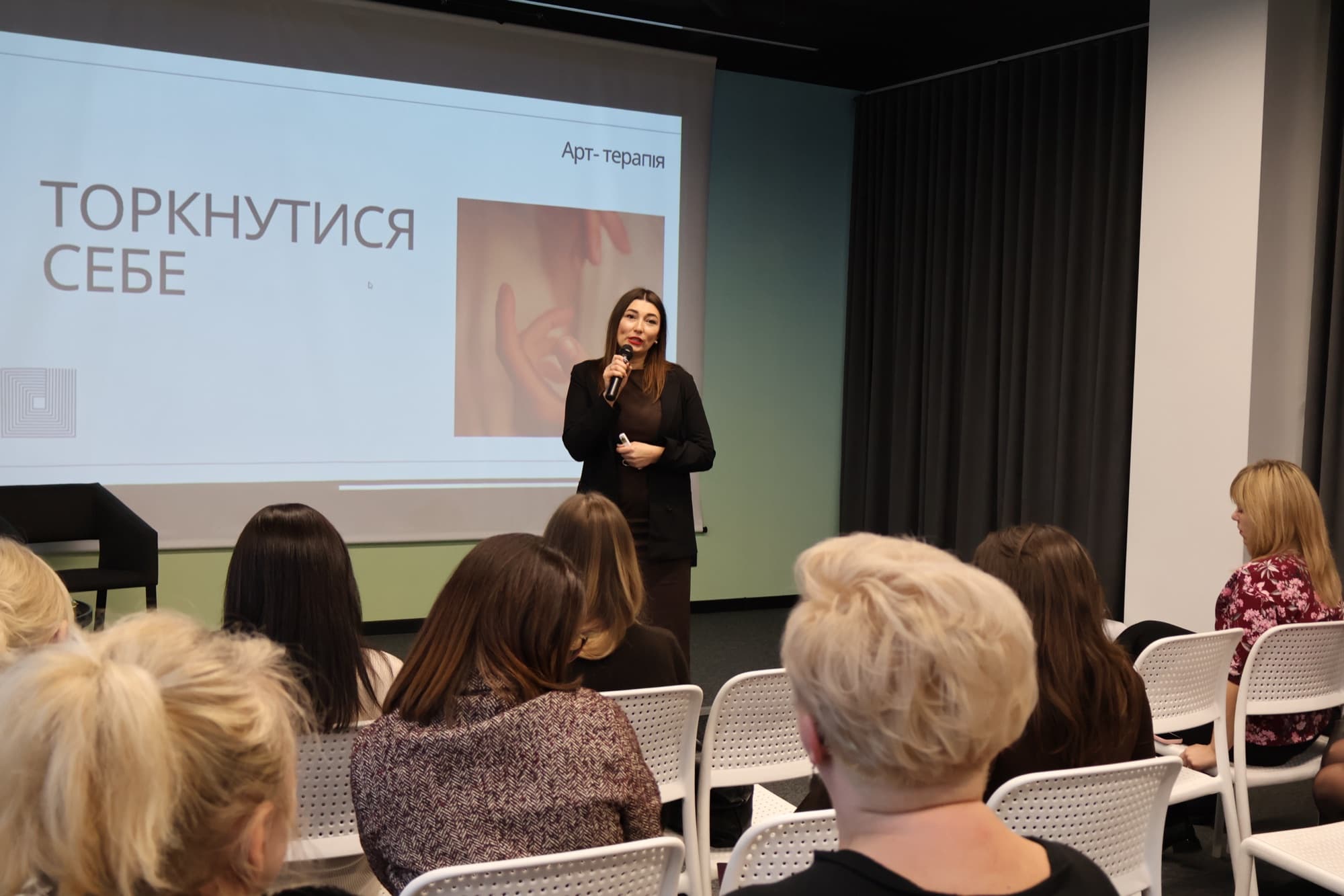 Анна веде тренінг для групи слухачів